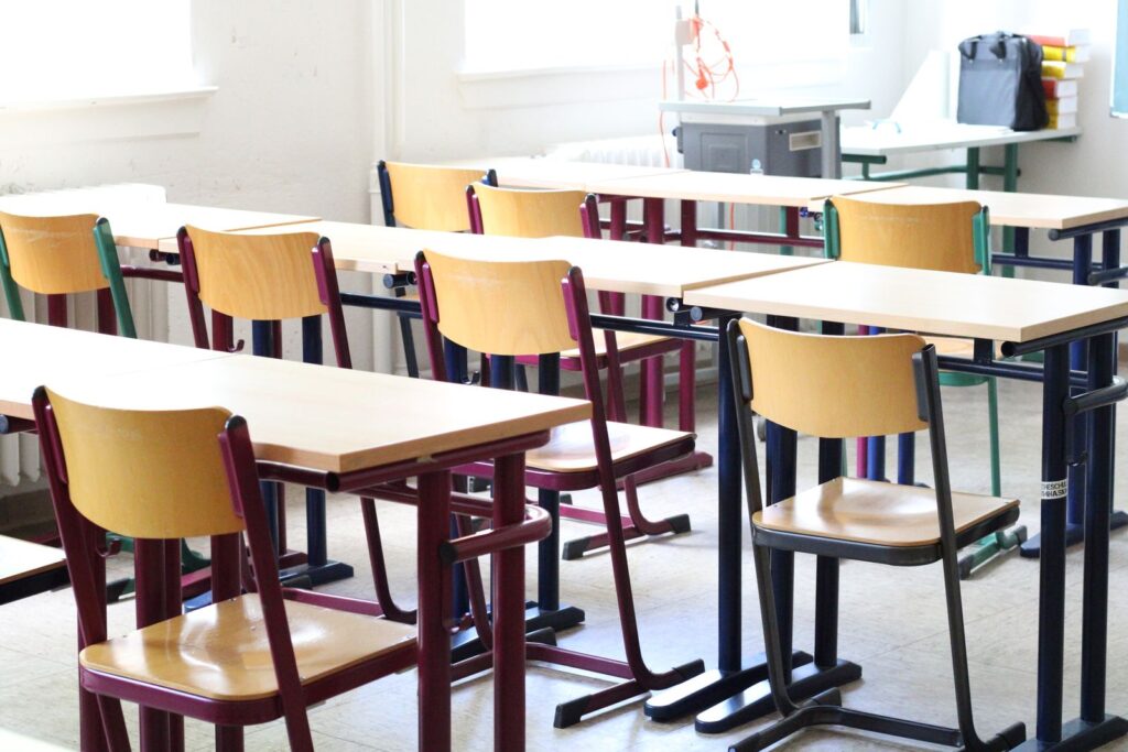 Sunlit classroom with wooden desks and chairs